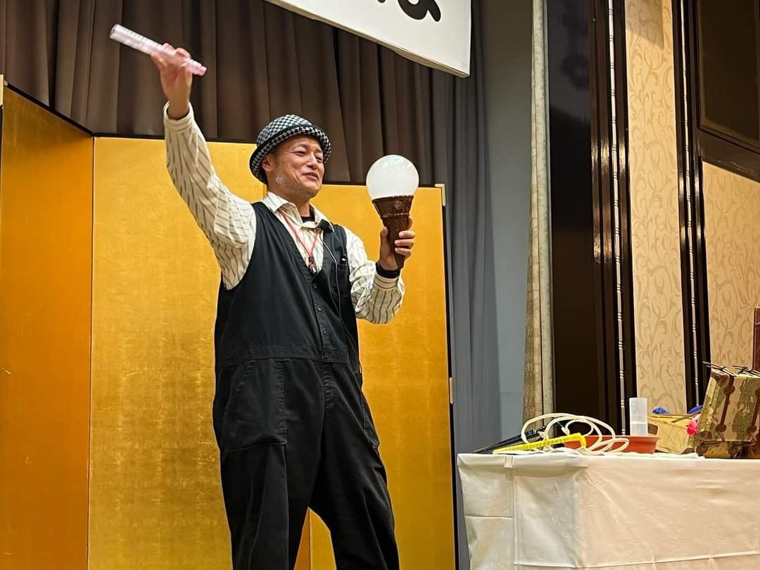 金屏風のある宴会場で、白いシャボン玉を手にパフォーマンスするシャボン玉おじさん
