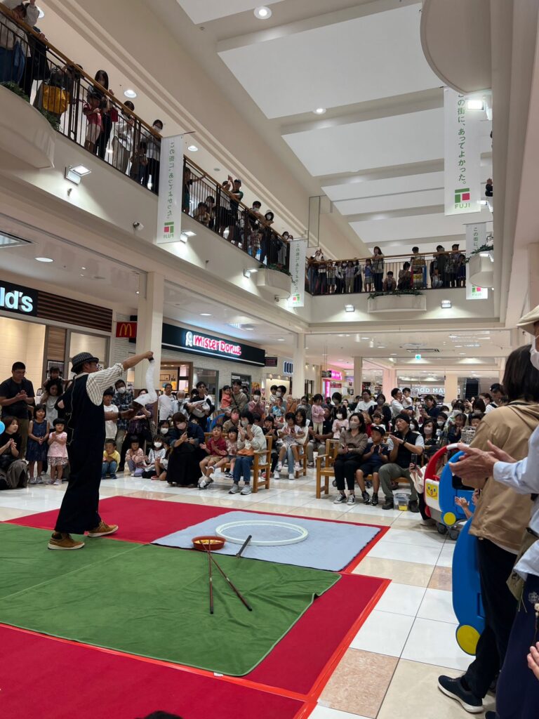 ショッピングモールの吹き抜けで行われたシャボン玉ショーと、見入る家族連れ