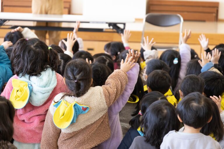シャボン玉ショーで、舞い降りるシャボン玉に手をのばす保育園の子どもたち