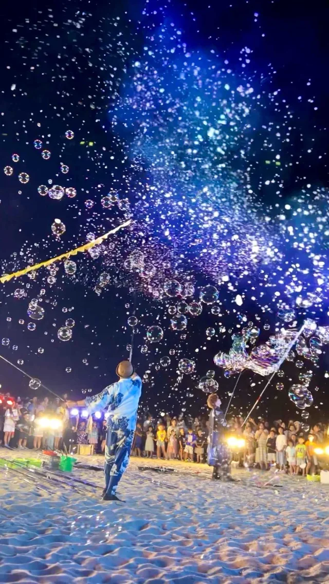 Kimono-clad performers release bubbles on a beach at night in Tottori, Japan