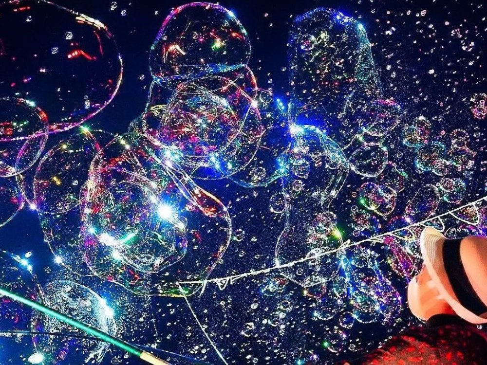 Guests photographing glowing bubbles with smartphones