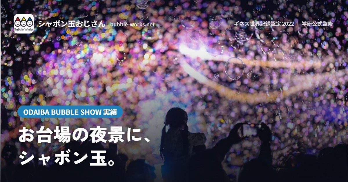 夜景の中で手をのばす観客とシャボン玉。ODAIBA BUBBLE SHOW